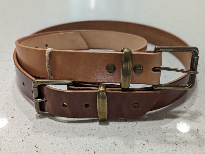 Two Moonlight Leatherworks leather belts in complementary brown tones with solid hardware